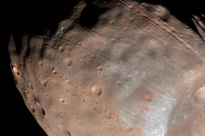 The grooves on the surface of Mars' moon Phobos are caused by tidal forces with the planet that are slowly leading to the moon's destruction