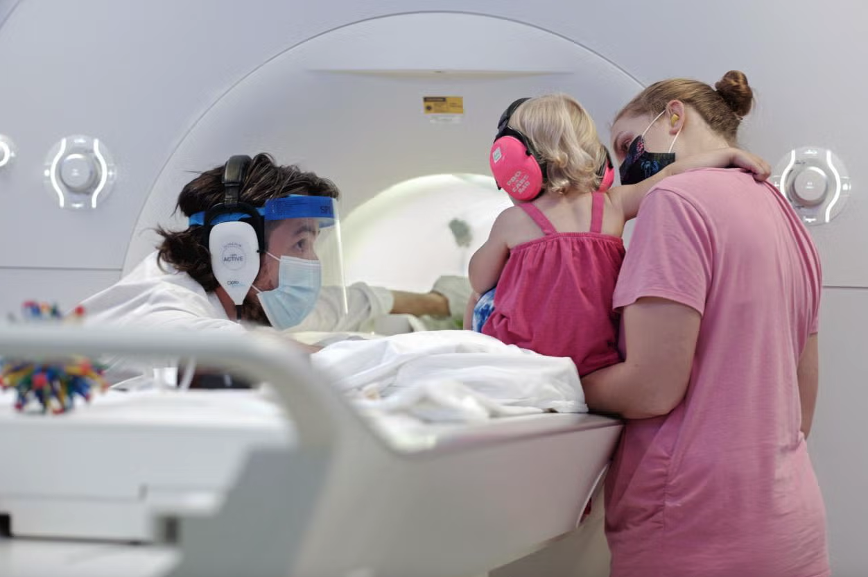 Yale scientist Nick Turk-Browne (left) preps a child for an fMRI for the study