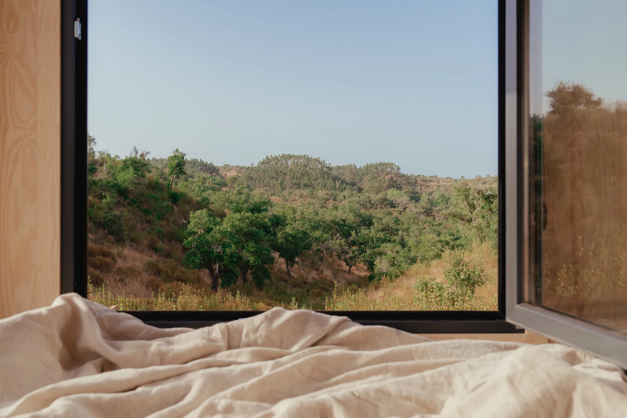 The tiny house's bedroom opens up to the outside with generous glazing