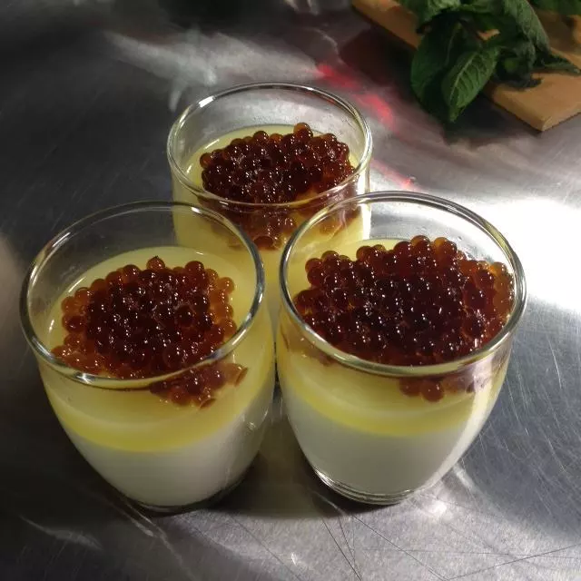Coffee liquor pearls made with the Spherificator, on lemon creme brulee