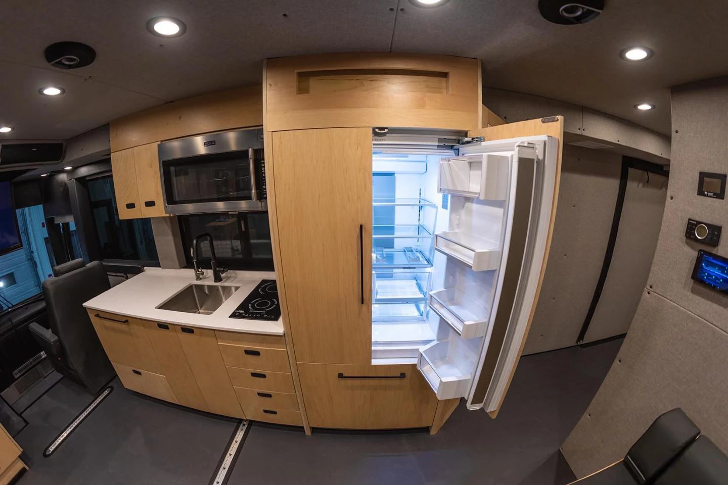 The Loki XL Coach includes a large residential-style fridge, induction cooktop, microwave and dishwasher