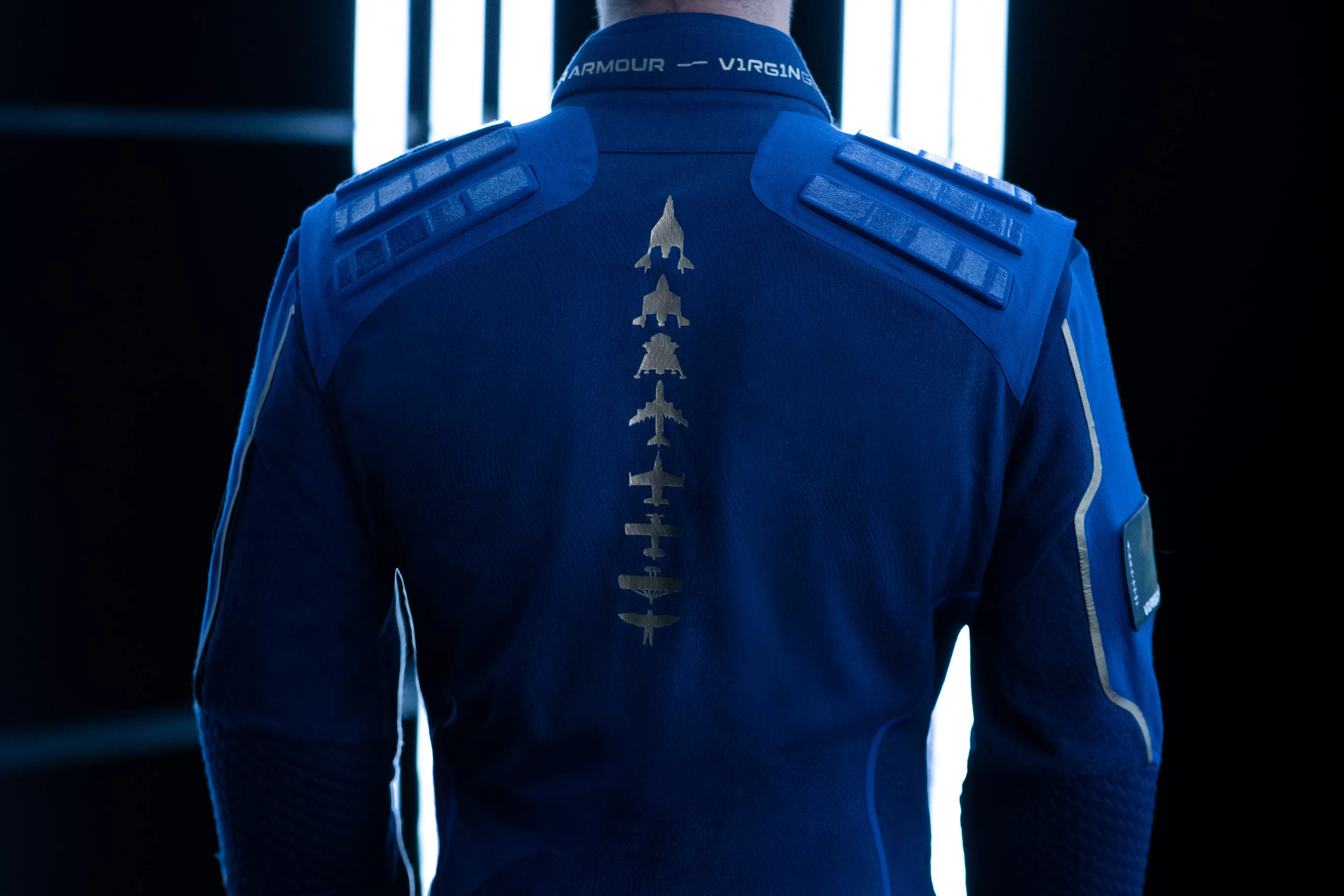 The suit includes symbols reflecting the evolution of flight