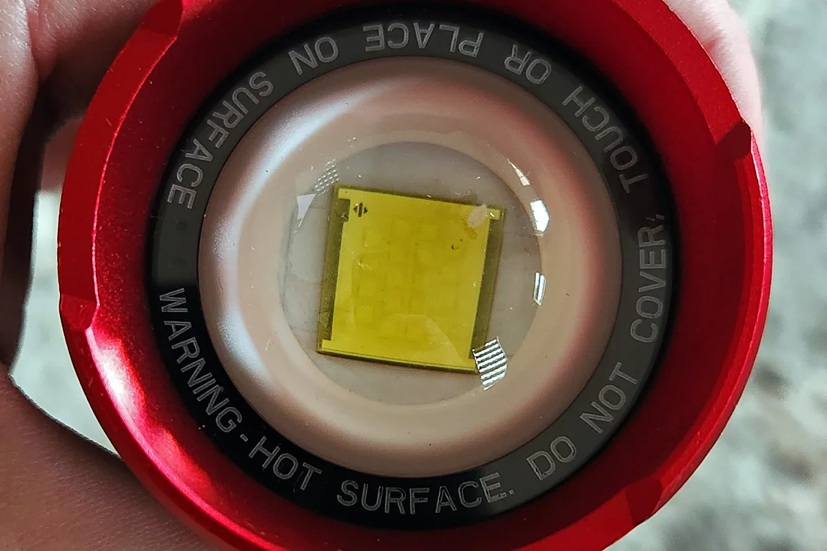 Behind the lens is a multi-die COB LED array with 20 small emitters doing all the work instead of a single fancy, expensive LED. Also, in the top right corner appears to be some sort of debris ... something you don't generally find in expensive LEDs