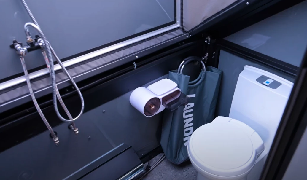 The toilet is on the wall opposite the sink, with the shower in between