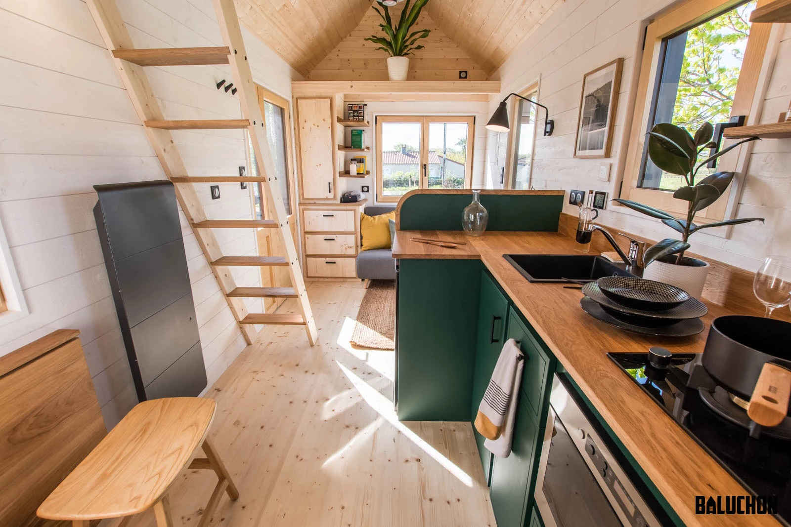 The Midgard's kitchen features a sink, oven, fridge, and two-burner propane-powered stove, as well as quite a lot of cabinetry and shelving