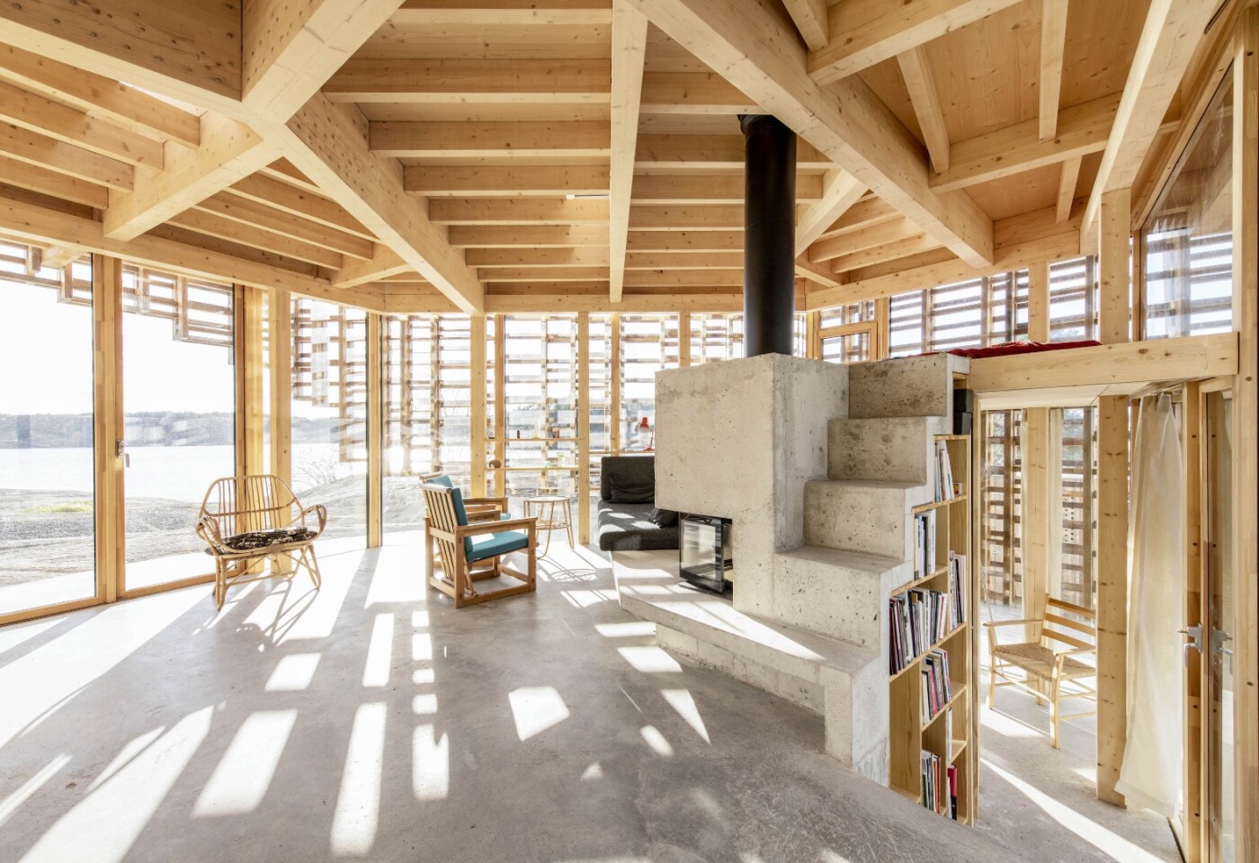A large concrete fireplace warms the House on an Island's open plan interior