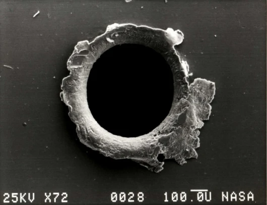 Space drive by? No that’s view of an orbital debris hole made in the panel of the Solar Max experiment.Image: NASA Orbital Debris Program Office