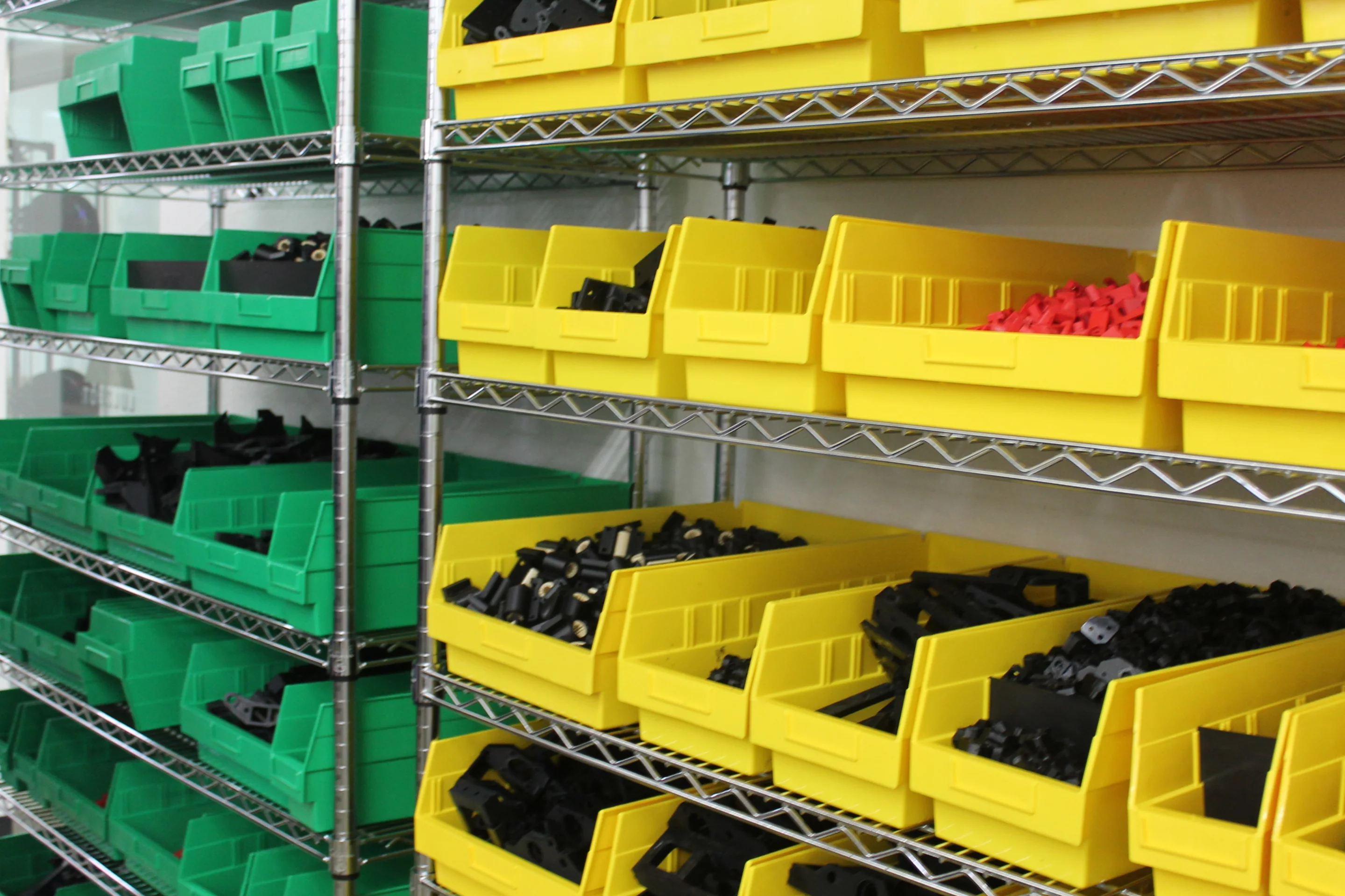 Shelves of parts wait after being printed to be installed into their own printer