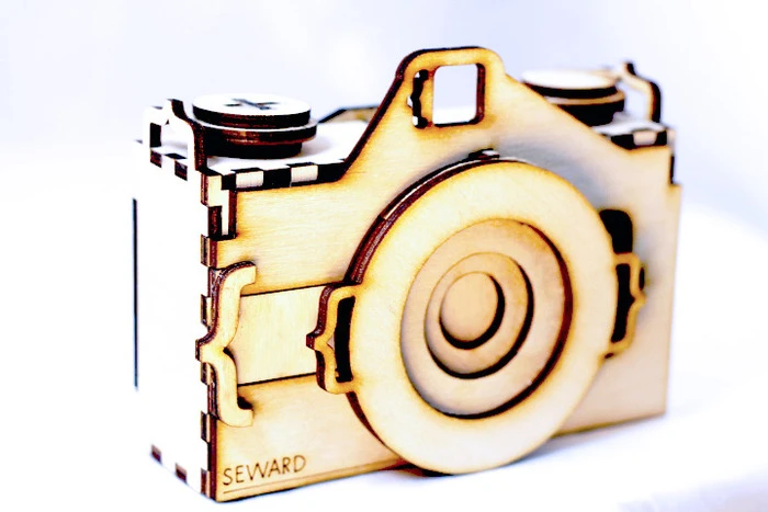 The lens kit consists of square piece of recycled aluminum, a size 22 sewing needle, a piece of 400 grit sandpaper and instructions for making the pinhole and assembling the camera