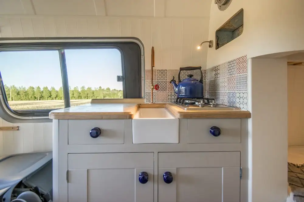 The Belfast sink helps give the kitchen a unique look in this tiny home-inspired van build from Jack Richens and Lucy Hedges