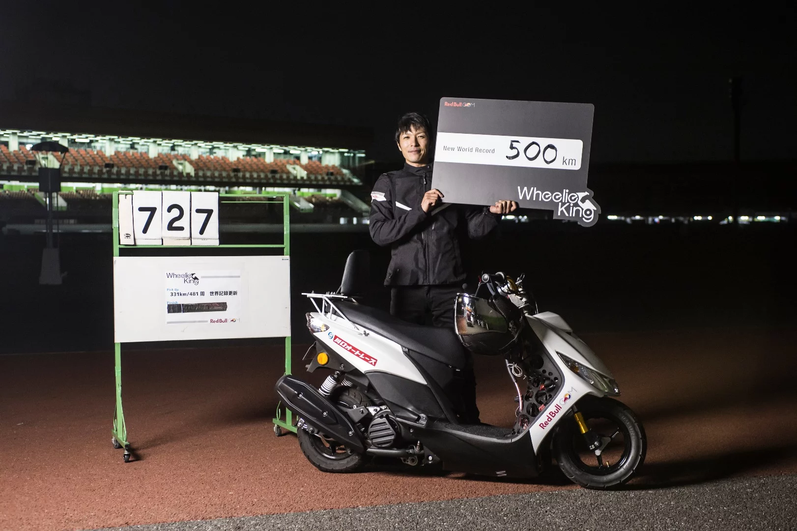 An exhausted Masaru Abe celebrates his 500 kilometre wheelstand