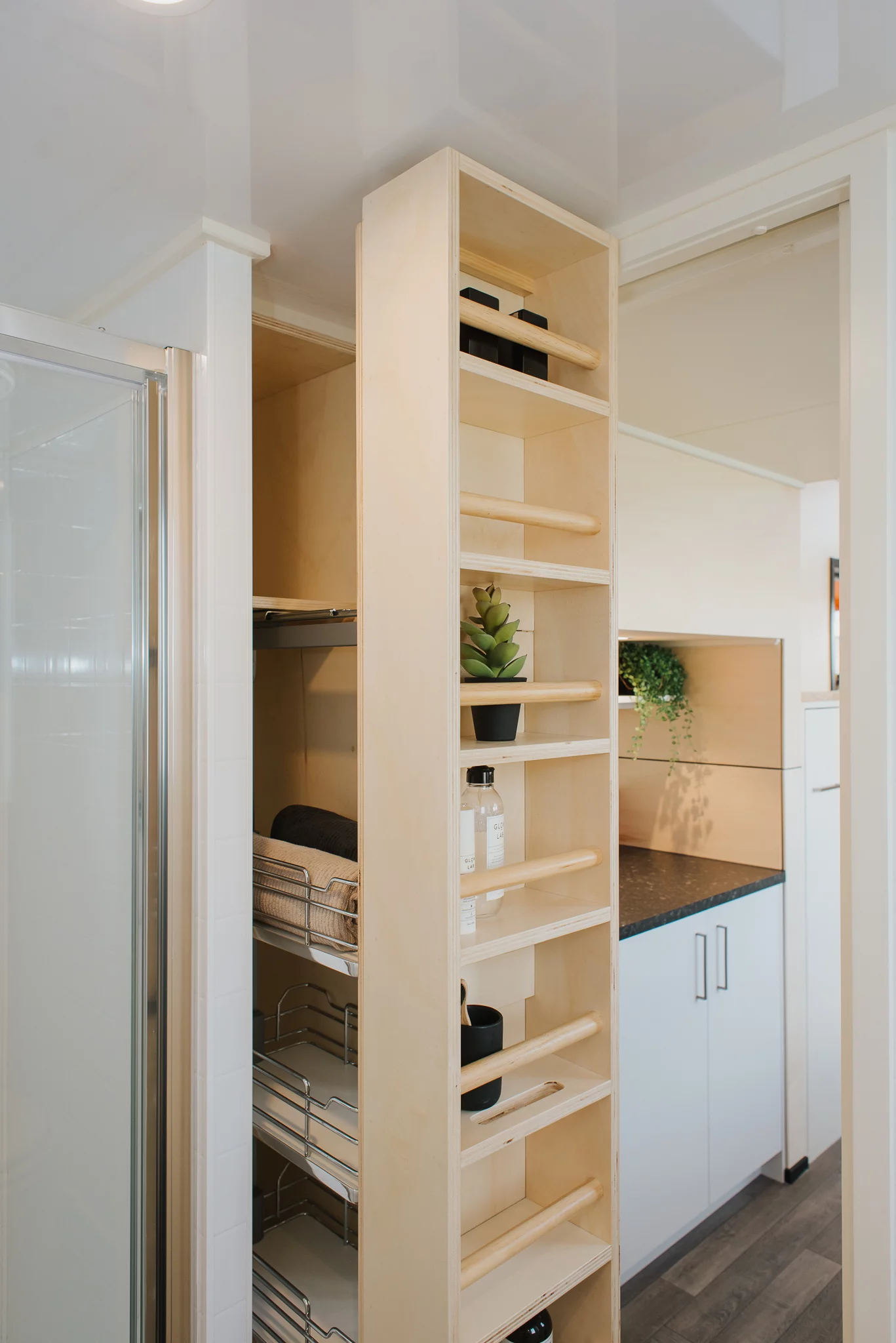 The Daisy Vera Tiny House's bathroom has a pull-out storage unit