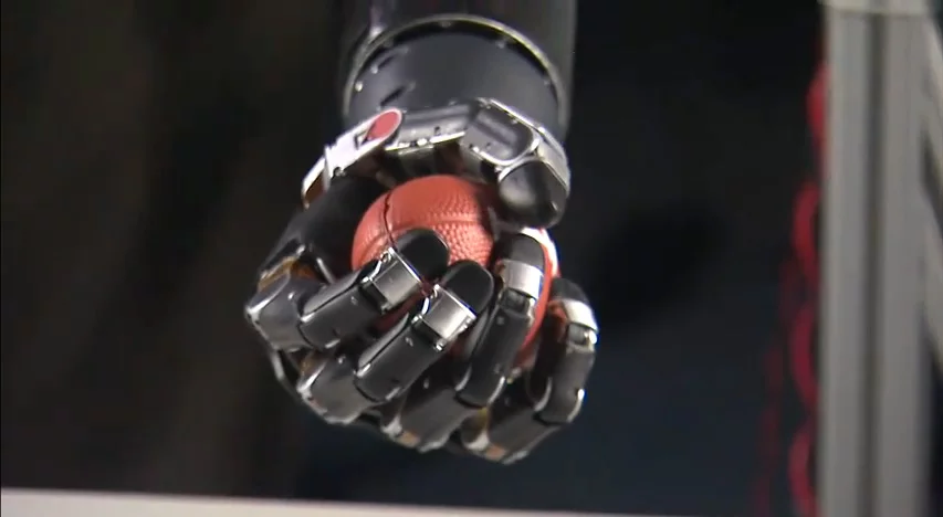 Johns Hopkins University's Modular Prosthetic limb easily grasps a wide variety of objects, such as this mini football