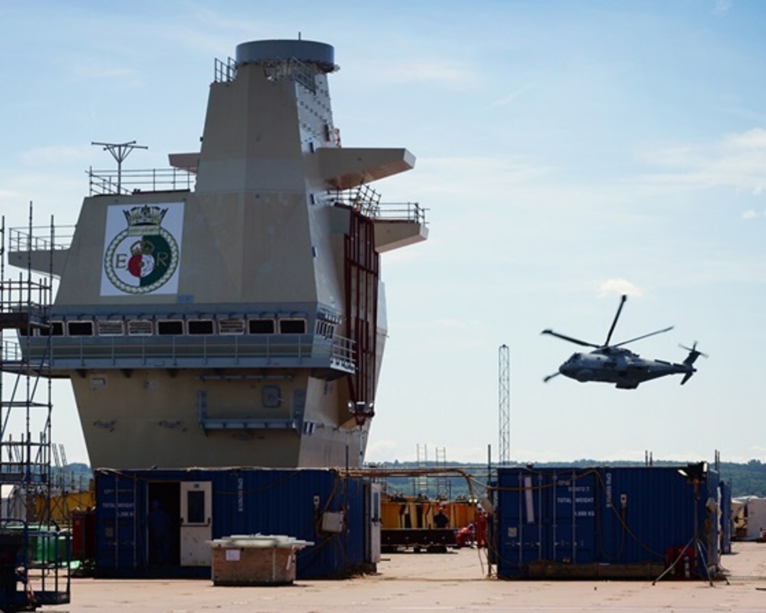 A Merlin helicopter flying over HMS Queen Elizabeth