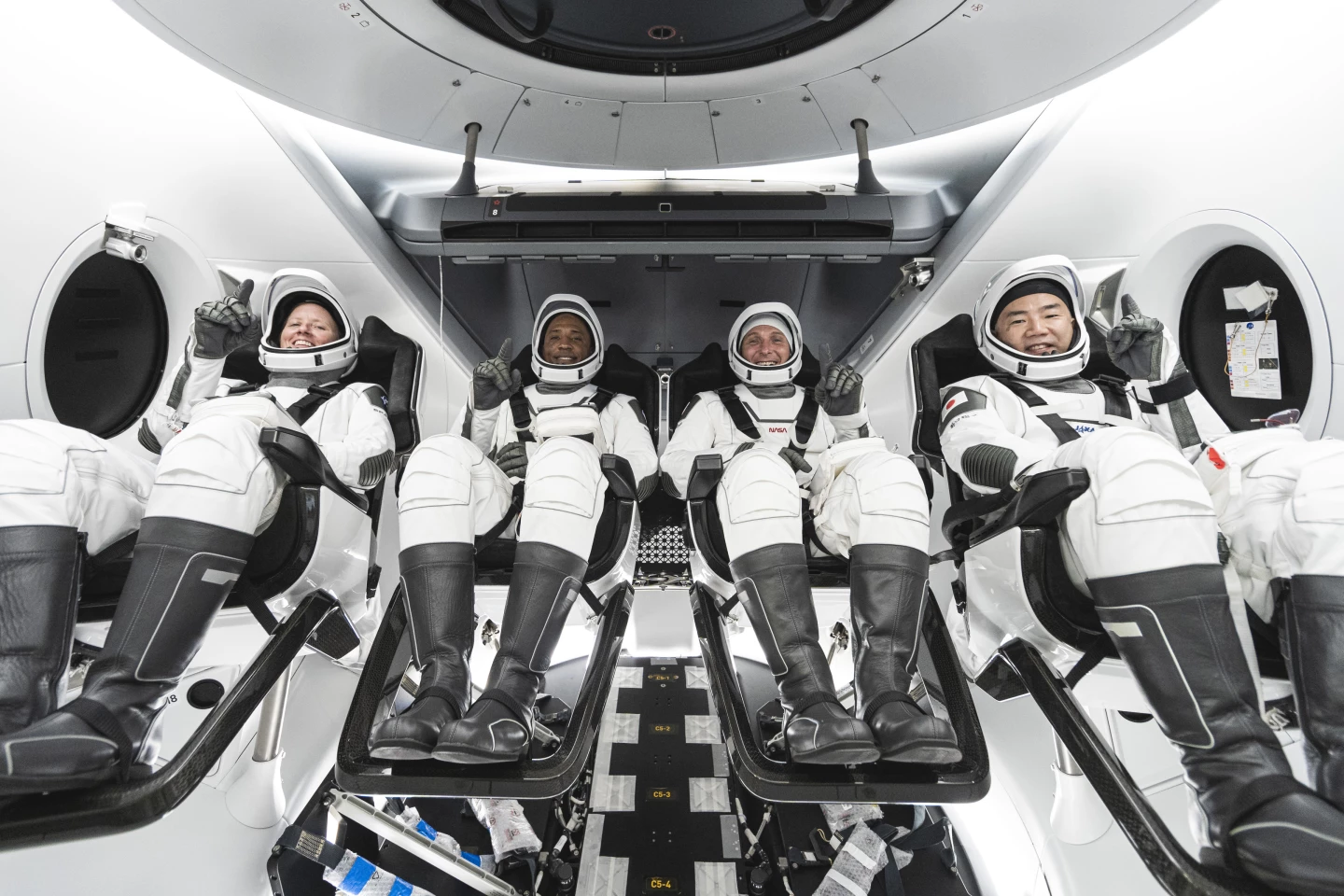 Astronauts Shannon Walker, Victor Glover, and Mike Hopkins, and astronaut Soichi Noguchi inside the Crew Dragon capsule