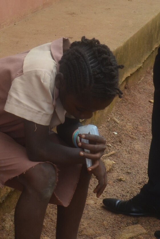 A primary school student spitting into a tube as part of the early saliva-test trials in Cameroon