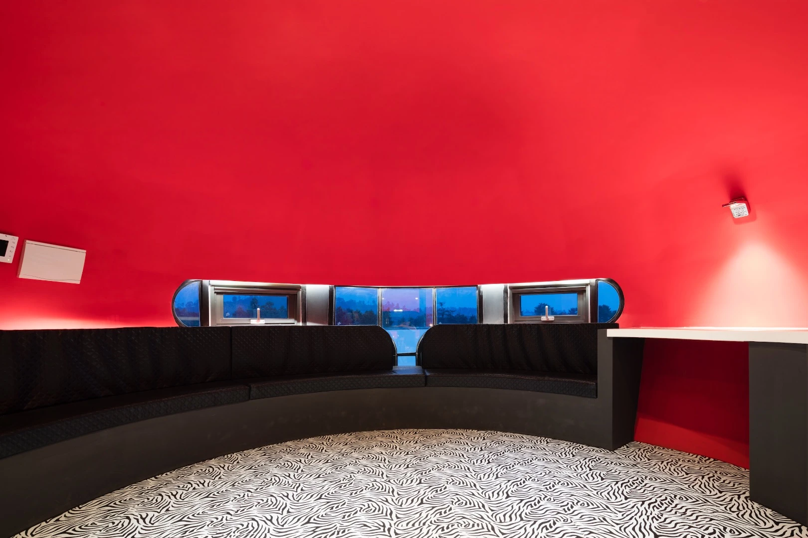 The interior of the golden pod is red, with 70s-like carpets and funky lighting