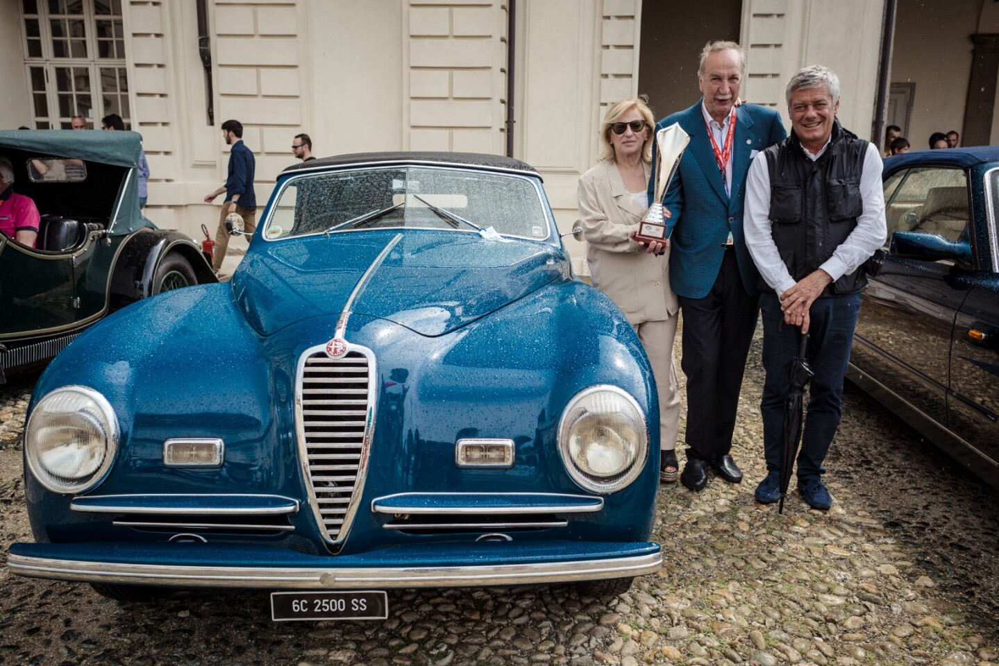 Often referred to as the last great Alfa, the immediate post WW2 Alfa Romeo 2500 6C Cabriolet Pininfarina Cabriolet was the last in the long line of six-cylinder Alfas that began in 1928 with the 6C 1500. Pictured with the class winning 2500 6C are the owners, the Manzoni family, and Paulo Pininfarina
