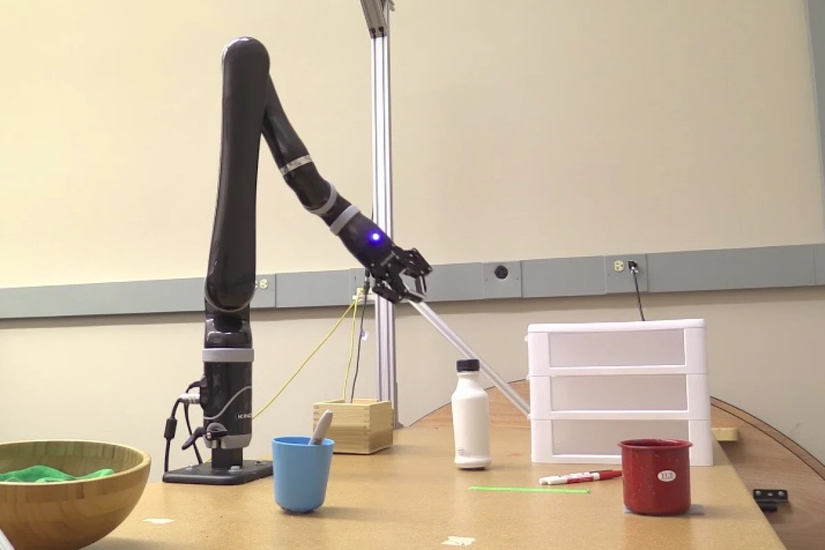 A robotic arm moves to pick up a felt pen