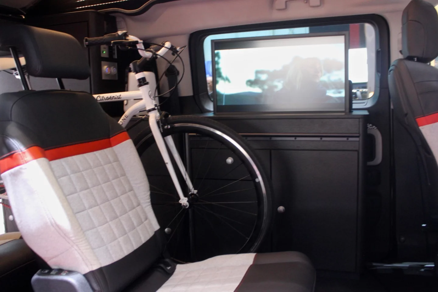 Two tandem rear seats stand next to the bicycle carrier