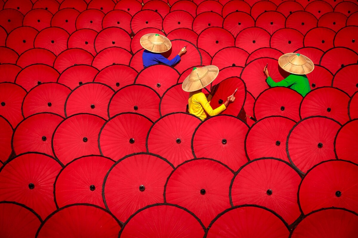 Three women workers painting traditional Myanmar umbrellas