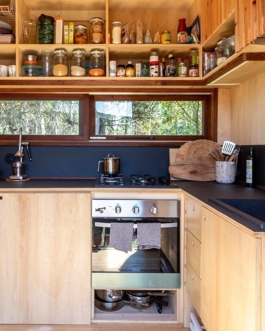 The Baleia's kitchen includes custom cabinetry and a four-burner propane-powered stove and oven