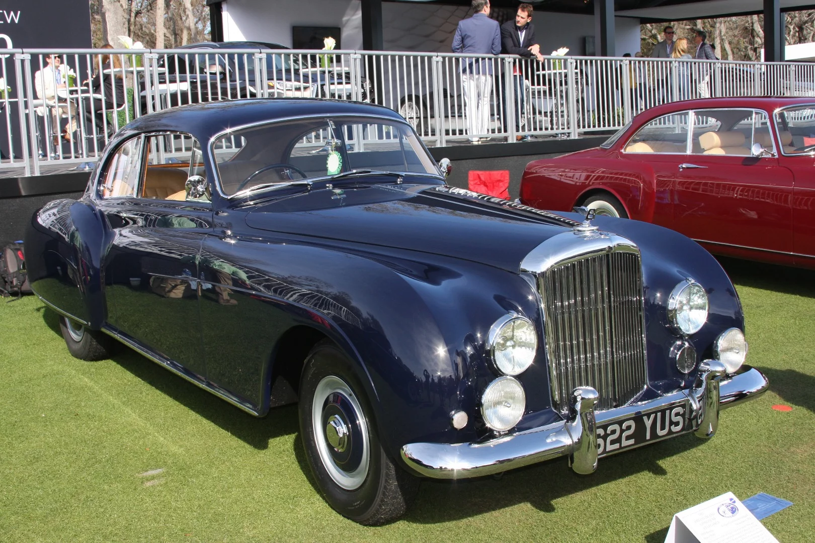 The first owner of this 1955 Bentley R-Type Continental Fastback was Raymond Montague Burton, head of the eponymous British high-street clothing chain founded by his father Sir Montague Burton. The car was ordered new, as one can do today with Bentleys, with a recess in the left hand door for picnic equipment, and a bespoke set of Bentley luggage. The common phrase "the Full Monty," originally referred to a complete 55 shillings Montague Burton outfit, with the suits for all the shops across Britain made in a workshop in Leeds which at its peak, produced 30,000 suits a week.