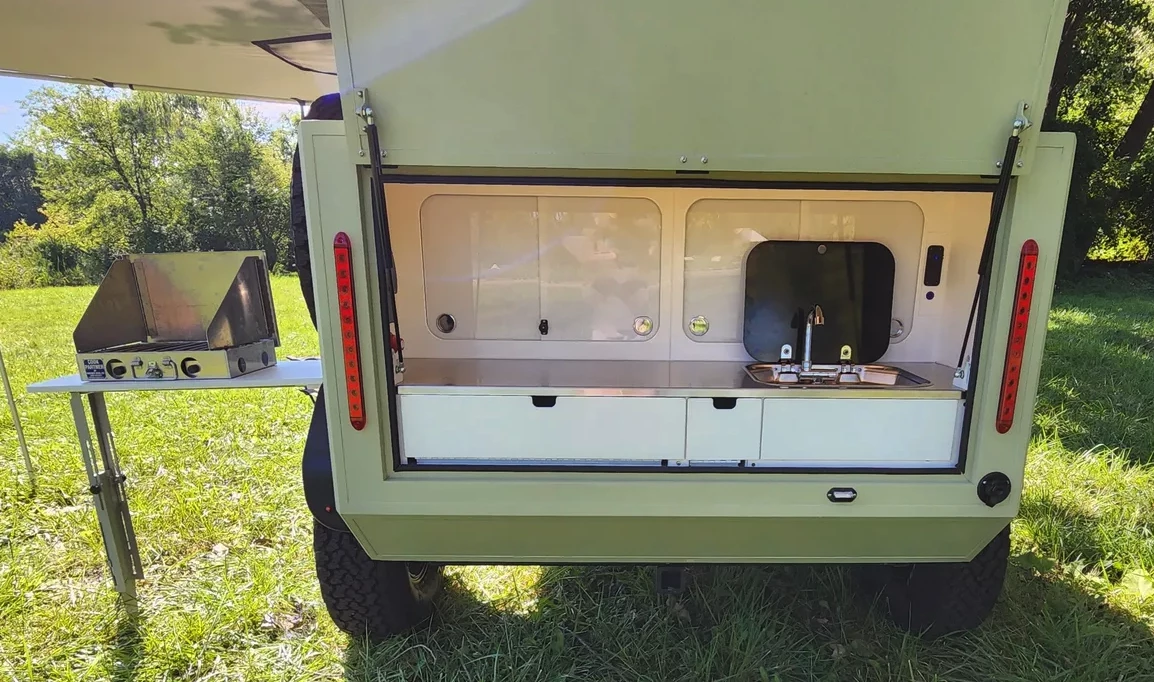 With the pictured side table, the kitchen opens up and offers plenty of space (no tailgate weather protection from the looks of it, though)