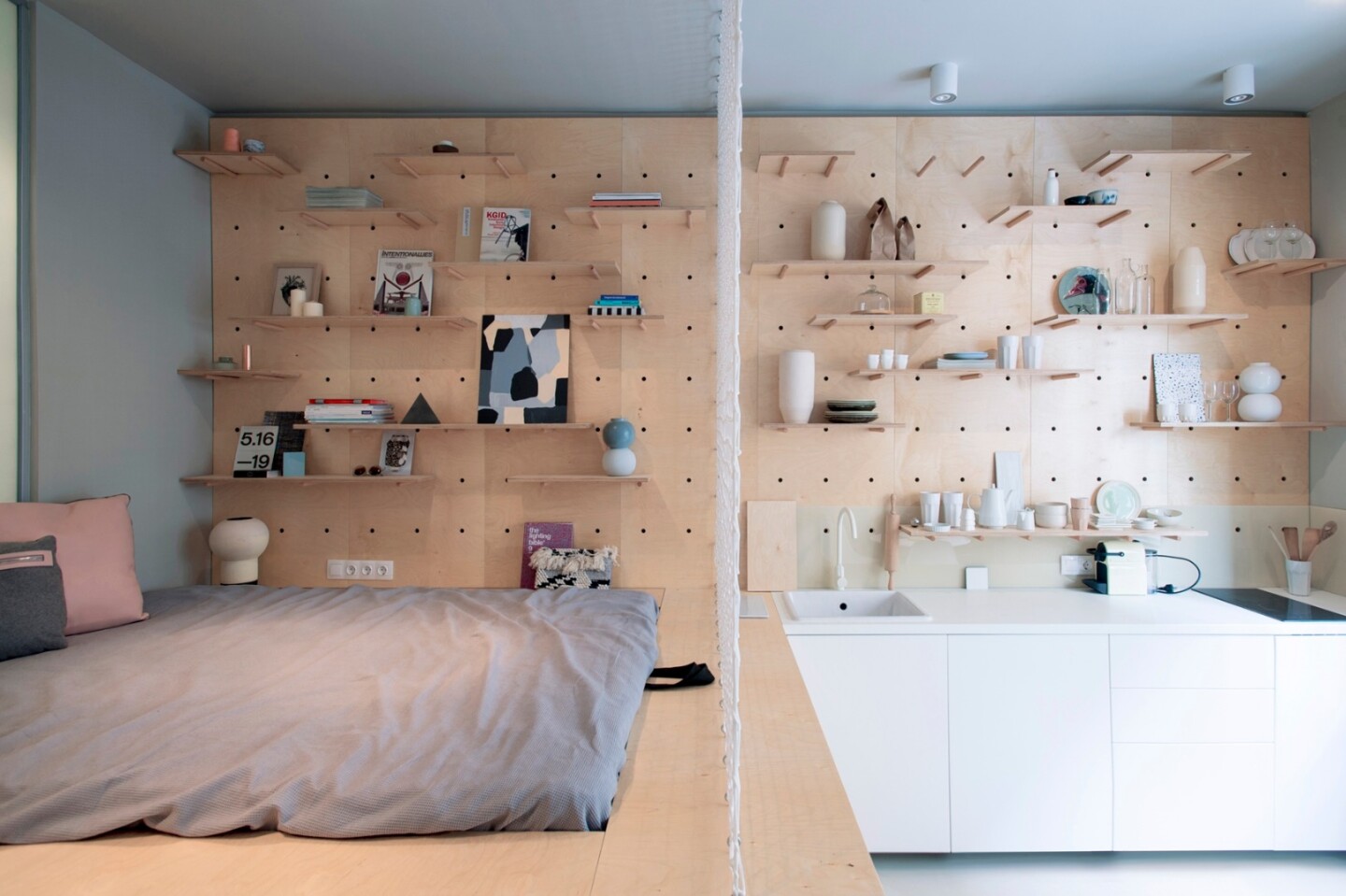 A net between the bed and the kitchen acts as a visual partition and could be used as a place to hang photos