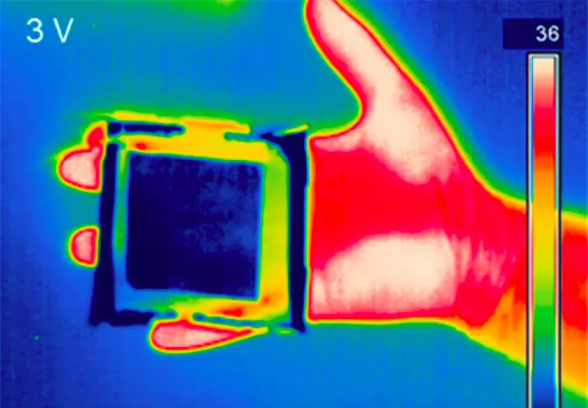 A piece of the material (blue square) masks the thermal signature of a human hand