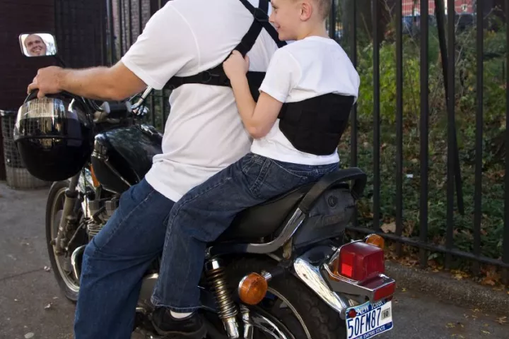 The Moto-Grip (seen here with the Moto-Grip Jr.) is a harness worn by a motorcycle operator, designed to let their passenger hang onto them better