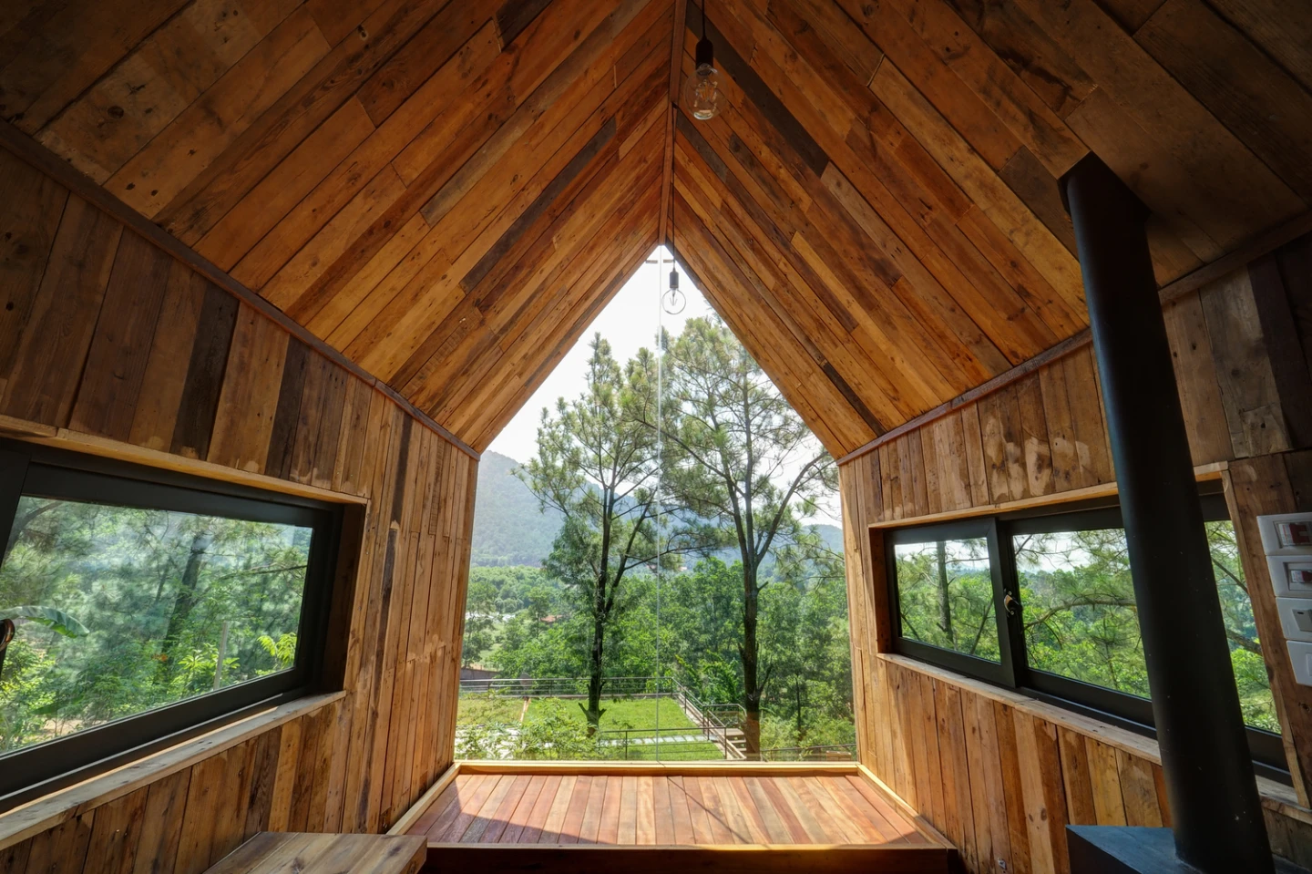 Constructed using local pine wood, the timber home is built into the side of aslope