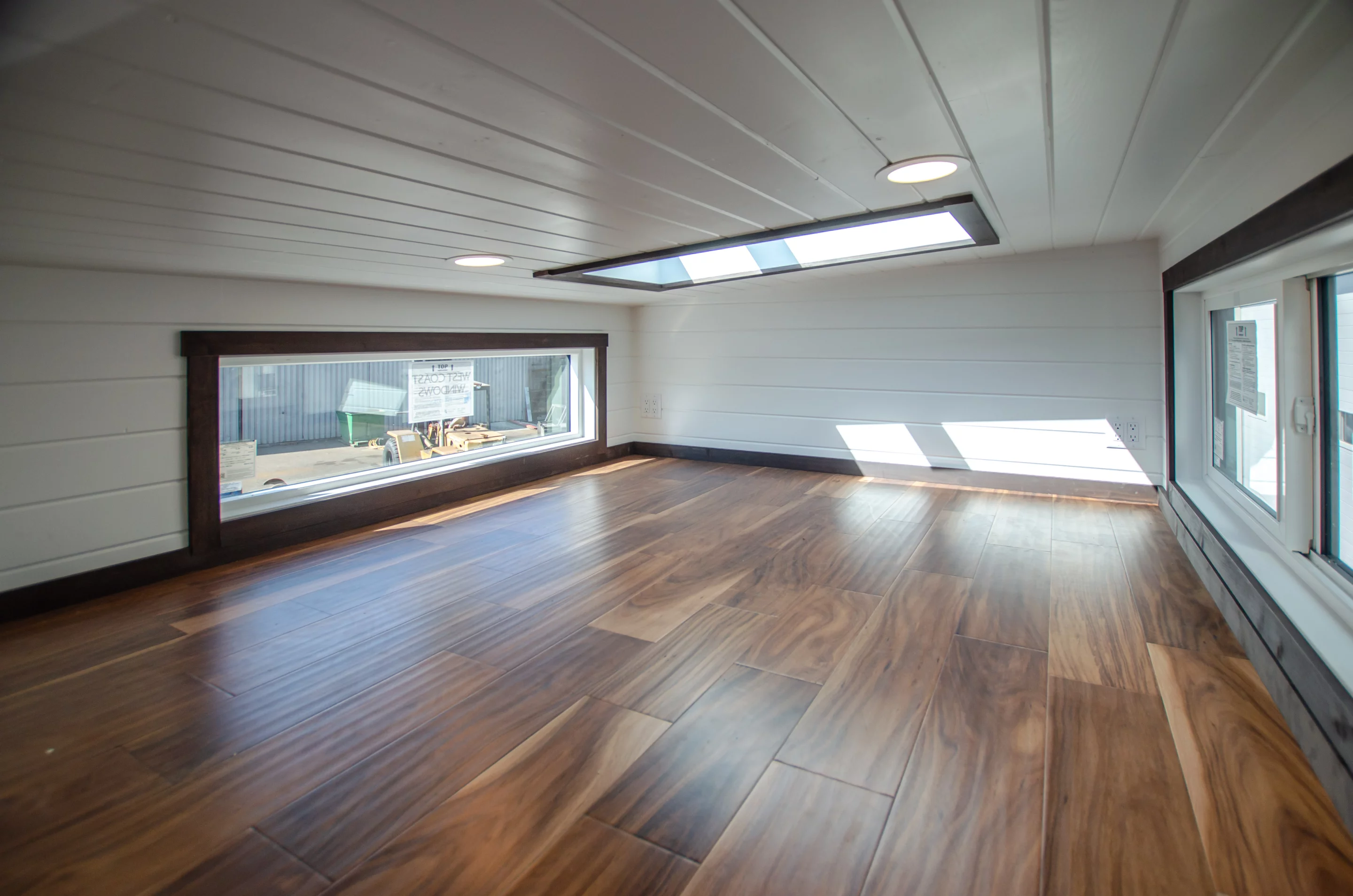 The Raven's main bedroom is a typical tiny house-style loft with a low ceiling and includes a skylight