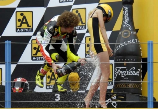 Marco Simoncelli and A-style promotional model on the victory dias at the Japanese Grand Prix