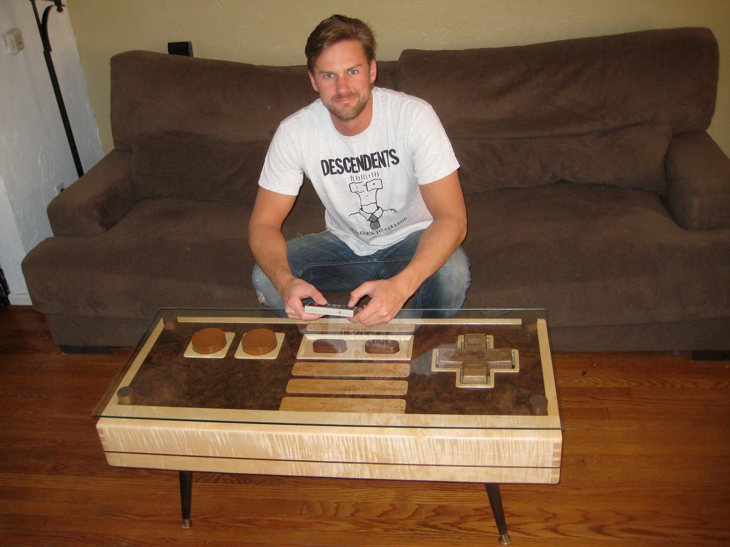 Charles Lushear with an original NES controller and his supersized, fully operational Nintendo Controller Coffee Table