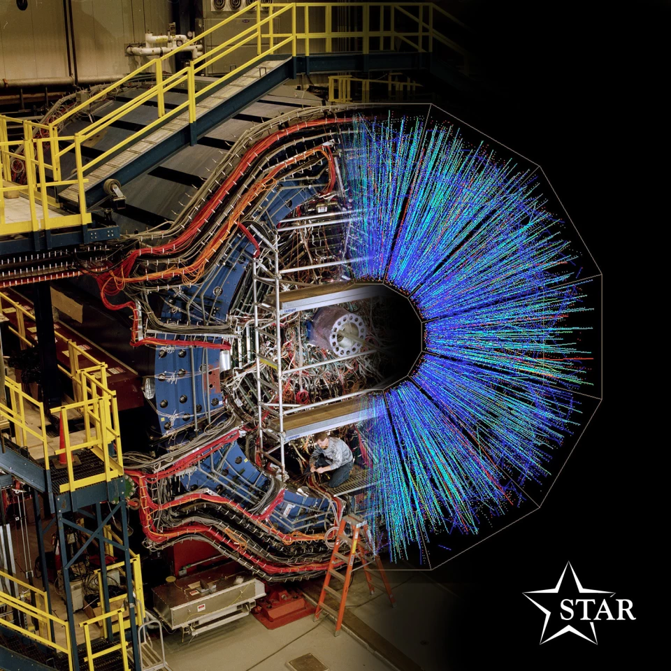 The STAR particle detector, overlaid with an image of the kind of particle tracks it detects