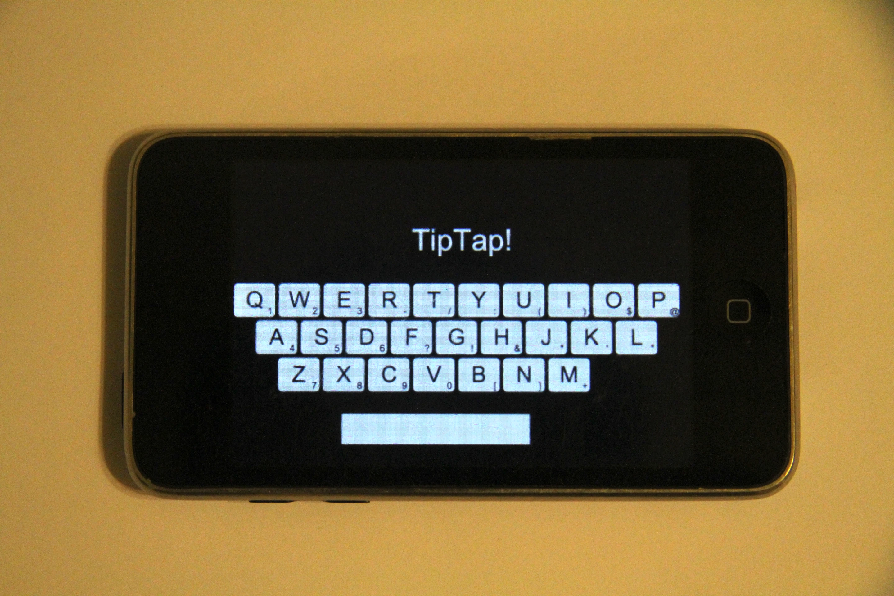 An example of a TapSense typing app, in which users access alternate characters on a virtual keyboard app by typing with the tip of their finger (as opposed to the pad), and backspace by nail-tapping