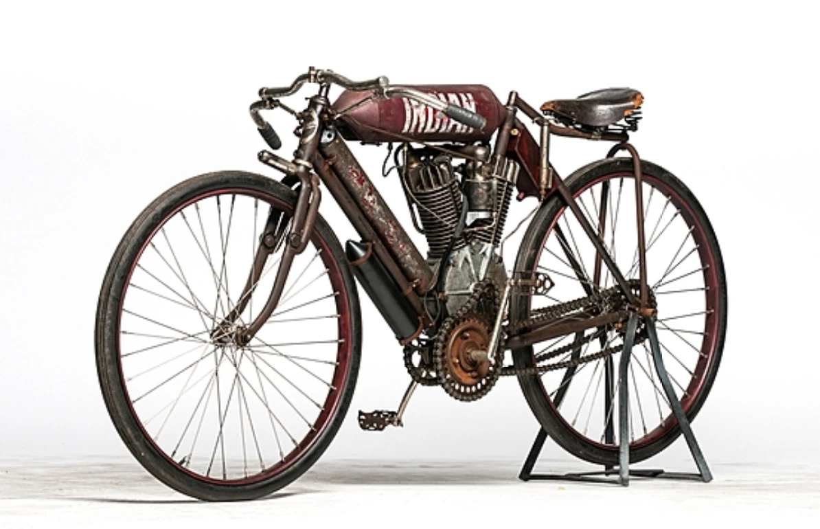 Specialised Indian racing machines first appeared in 1905 that were visibly different from the catalog offering, including a new V-twin engine, which was first offered to the public in racing form in 1908. That first 60.32 cu-in. engine retained the ‘automatic’ inlet valve and mechanical exhaust of the singles, although this ‘monkey on a stick’ twin racer was advertised as capable of 65 mph ‘according to gear,’ with a single Corbin coaster-brake on the rear wheel… racing was always for the brave! Other specifications included Hedstrom mica spark plugs, an English Brooks racing saddle (the B-100 or B-100-4 for ‘heavy riders’), and an all-up weight of 120lbs. Colors available were Indian Royal Blue (the standard), with options of black or Indian Red. The magnificent Twin-Cylinder Indian racer could be yours for $360. This E.J. Cole ‘monkey on a stick’ 1908 Indian Twin-Cylinder racer was purchased from D. Ollhoff, and retains its original parts, while remaining in unrestored condition. This bike sold for $110,000 as part of the EJ Cole Collection.