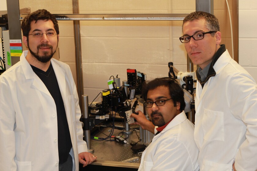 MIT researcher Ed Boyden (left) and Georgia Tech researchers Suhasa Kodandaramaia (seated) and Craig Forest have developed a way to automate the process of finding and recording information from neurons in the living brain (Photo: MIT)