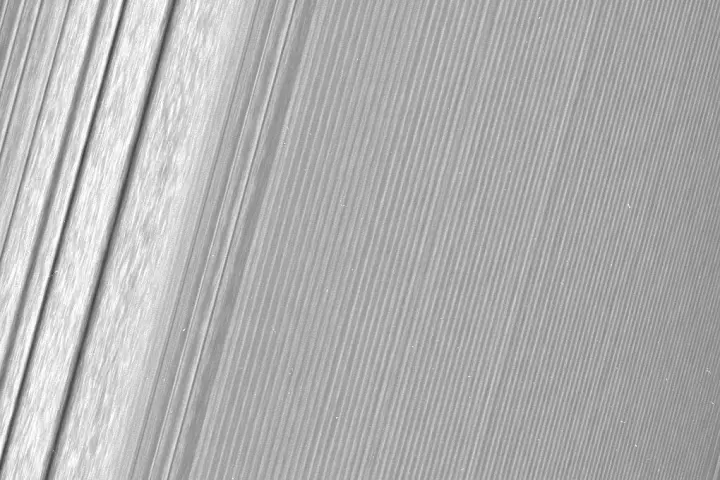 Cassini image of Saturn's A ring featuring a density wave (to the left) and the more subtle wakes created by a ring moon (to the right)