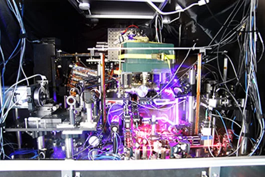 JILA’s experimental atomic clock captured as a composite of many photos taken with long exposure times and other techniques to make the lasers more visible (Photo: Ye group and Baxley/JILA)