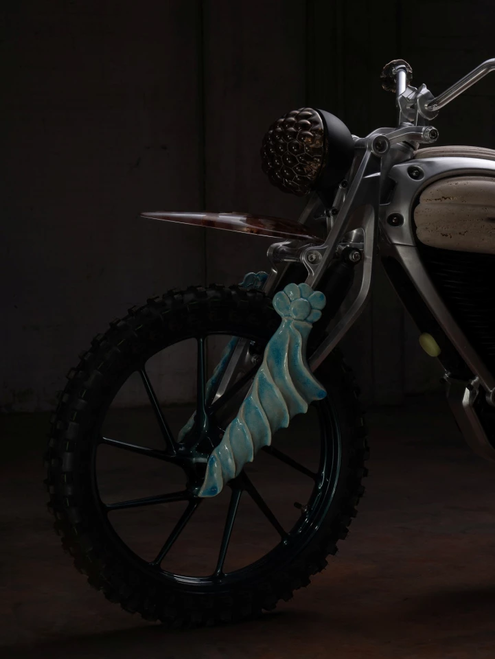 The parallelogram forks, which resemble the fork guards found on scrambler motorcycles, have hand-modeled clay details
