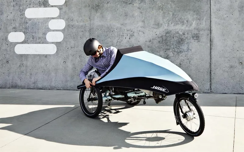 Hase Bikes' KLIMAX tricycle features a detachable folding fairing, allowing users to add weather protection as needed