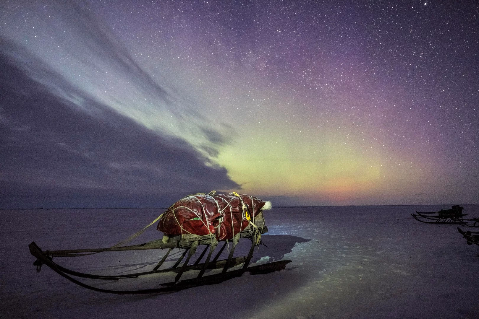 The boundless and snow-covered landscape of the tundra is the natural habitat of the Nenets people and their reindeer that live in perfect harmony with the environment and with humans. The need of food drive the reindeer to migrate along the Yamal Peninsula. The sleds are now ready for the next migration and the Northern Lights can only be considered as a positive signal sent to the Nenets by the spirits of the tundra