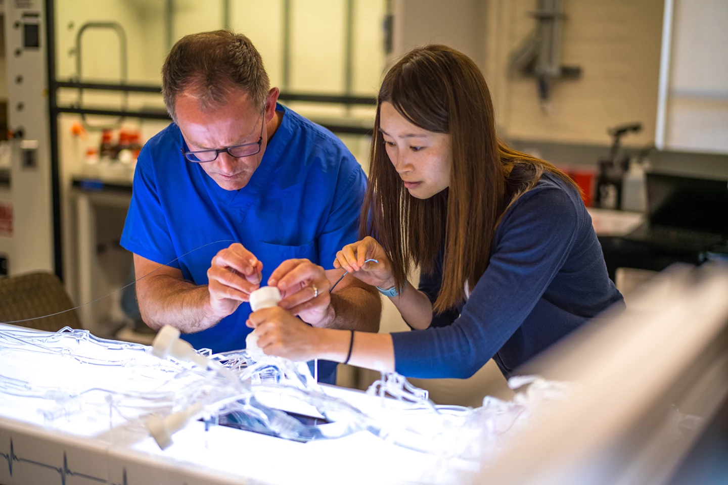 Jeremy Heit (left) and Renee Zhao demonstrate how to insert the milli-spinner using a life-sized model of the human circulatory system