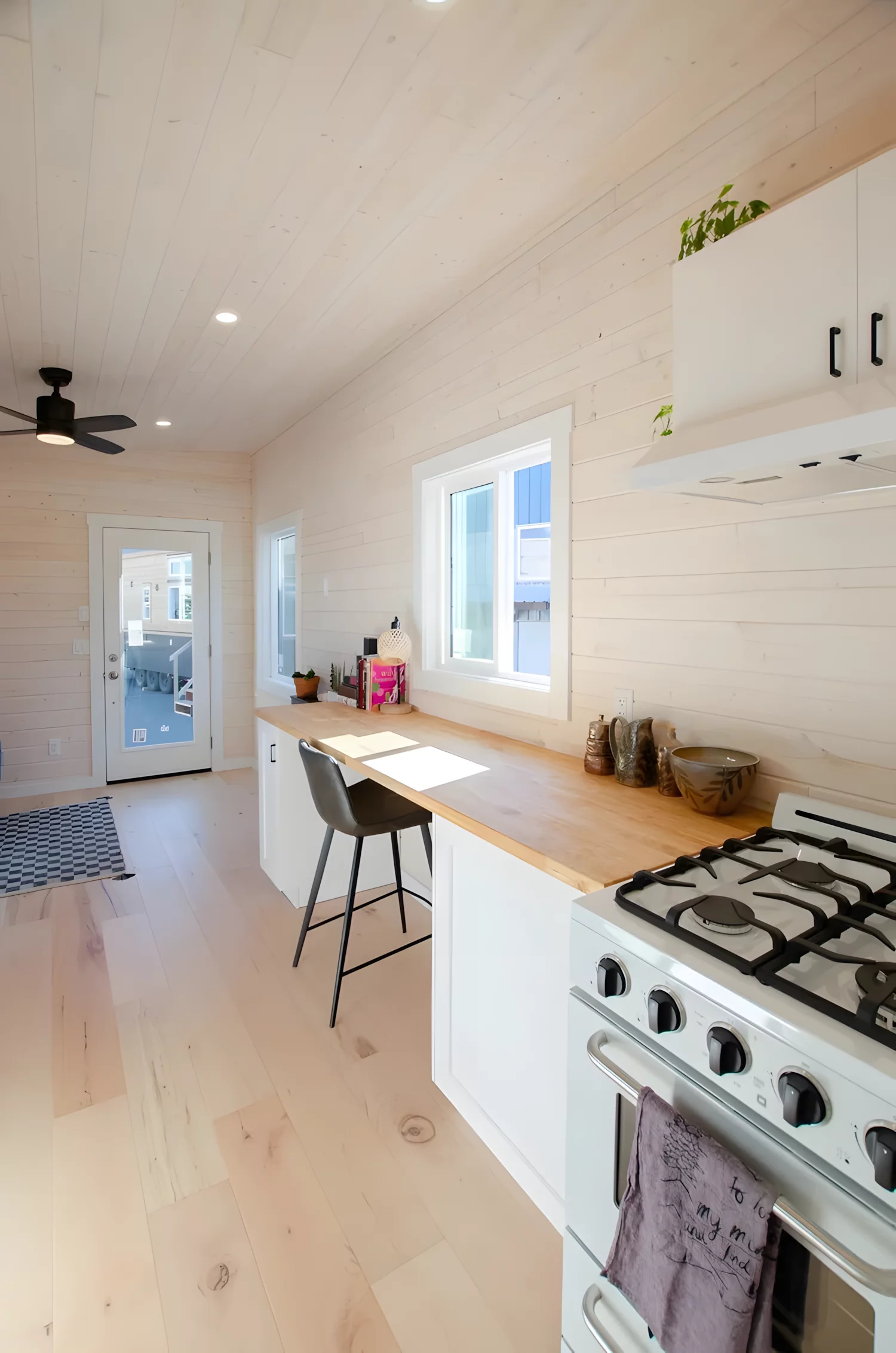 The Barred Owl's galley kitchen includes a full‑size fridge, a sink, and a propane oven with four‑burner cooktop