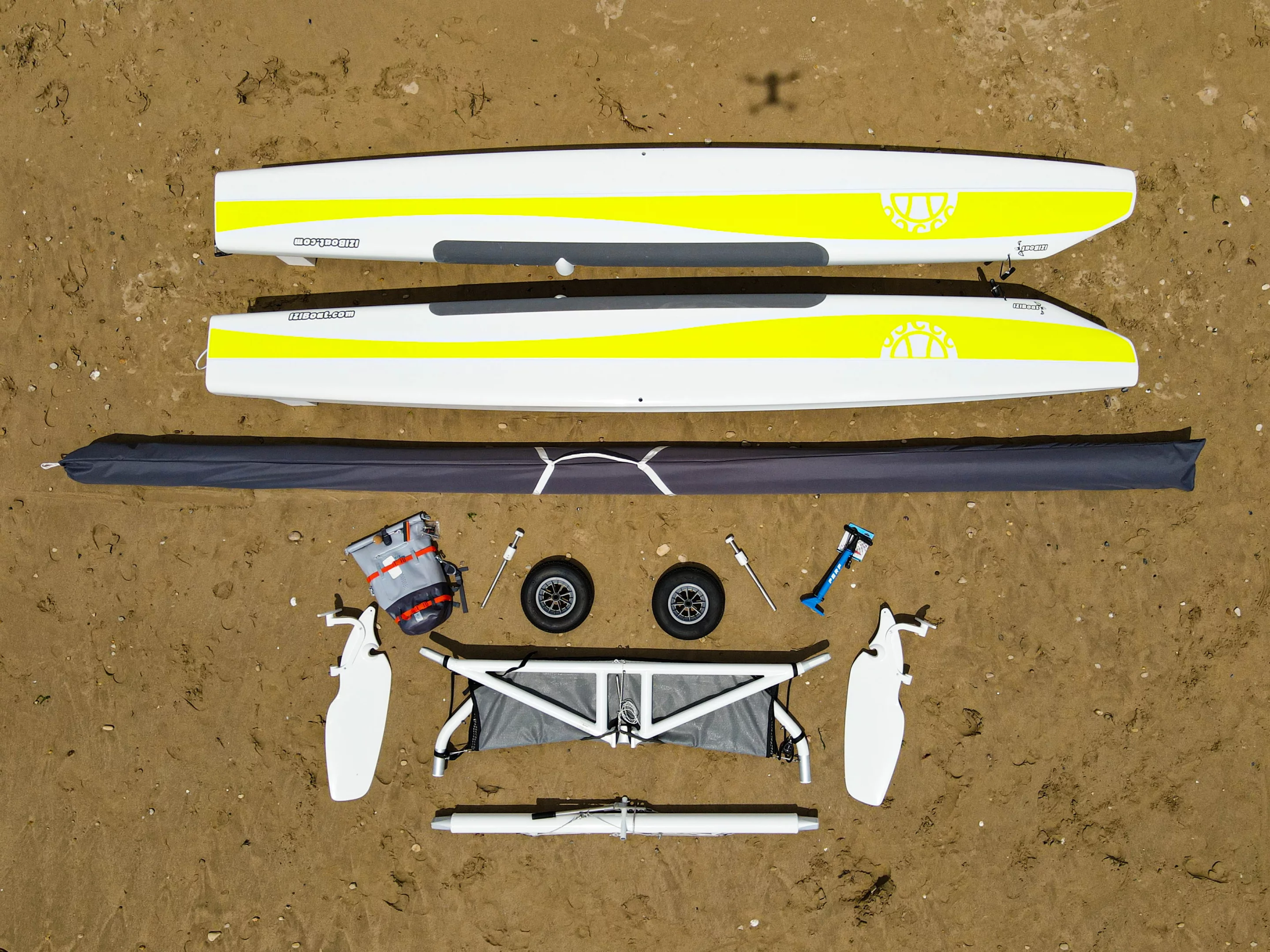 The hulls are made from a composite and coated in a gel to withstand abrasion from sand, the mast is made from aluminum and fiber, the frame can seat four, and an electric motor is being added as an option for 2024