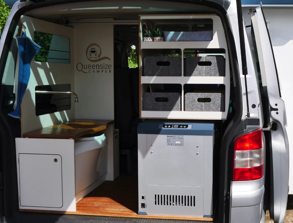 Shown here on the Galeria ForFour, Queensize's bathroom design features a swivel-away faucet and fold-down wooden sink design that drains into the toilet, saving space versus separate toilet and sink fixtures