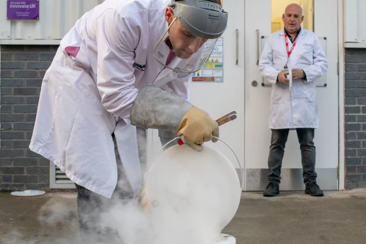 Dr. Thomas Grandjean utilizes liquid nitrogen to freeze a lithium-ion battery