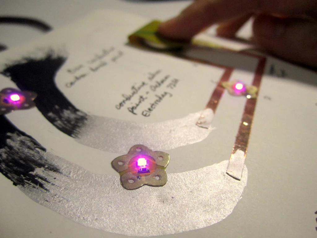 Sticker prototypes demonstrating their use on carbon, silver pen, and copper tape as conductors